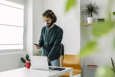 Freelancer using mobile phone at desk in office