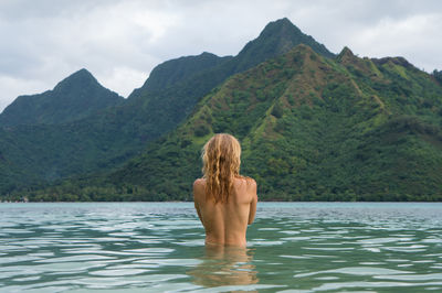 Rear view of shirtless woman in lake