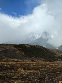 Scenic view of mountains against cloudy sky