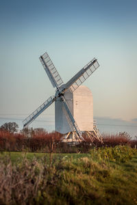 Traditional windmill on field against clear sky