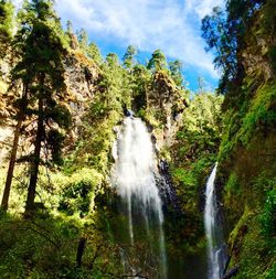 Low angle view of waterfall against sky