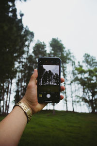 Midsection of person photographing with mobile phone