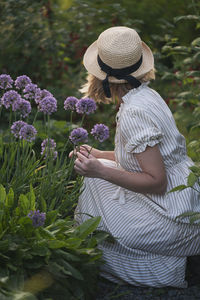 Rear view of woman picking flowers
