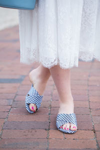 Low section of woman standing on footpath