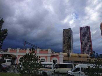 Buildings in city against cloudy sky