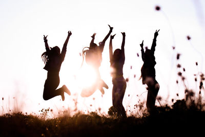 Group of people on field against sky during sunset