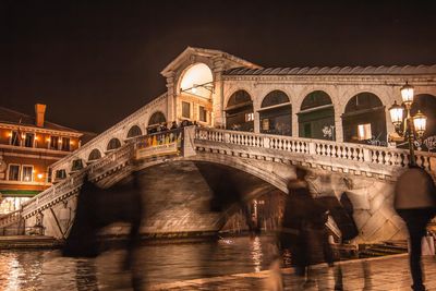 Arch bridge over river at night in venice 