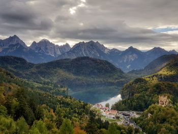 Scenic view of mountains, lake, forest and castle against grey sky - view from neuschwanstein castle