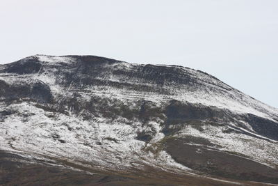 Low angle view of snowcapped mountain against clear sky