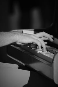 Cropped hand of woman playing piano