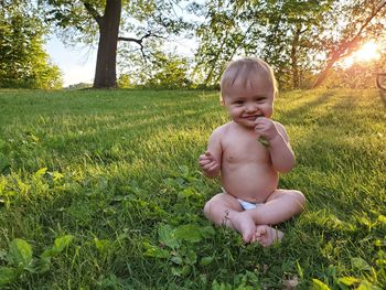 Portrait of cute baby boy sitting on land