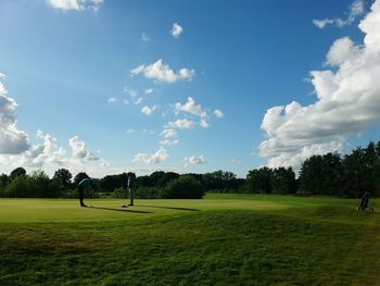 Scenic view of golf course against sky