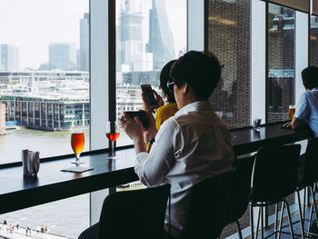 Rear view of a man holding glass window