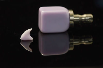 Close-up of lit candle on table against black background