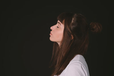 Portrait of woman against black background