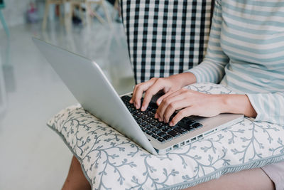 Midsection of woman using laptop