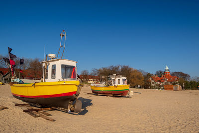 Boat on beach against clear blue sky