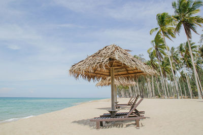 Parasol and lounge chair at tropical beach