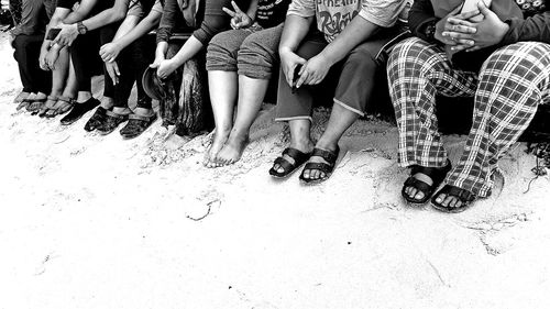 Low section of people sitting at beach