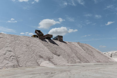 Low angle view of man standing on rock formations against sky