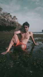 Young man in sea against sky