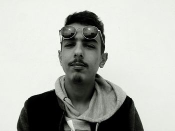 Low angle portrait of young man wearing sunglasses against clear sky