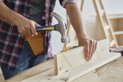 Midsection of man working on wood