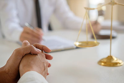 Close-up of man discussing with lawyer on table