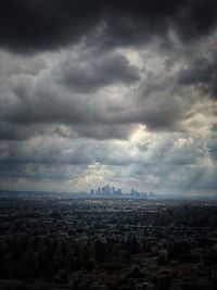 Aerial view of city buildings against storm clouds