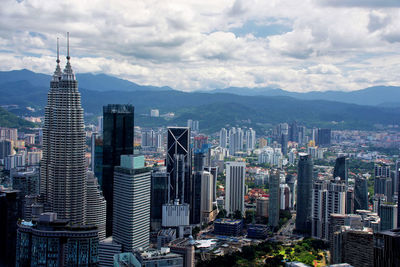 Aerial view of kuala lumpur with twin towers against sky