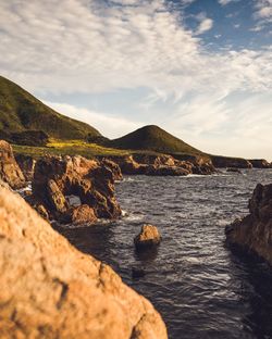 Scenic view of sea and mountains against sky