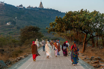 People walking by jain temples and shrines against  mount satrunjaya near palitana, india