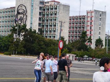 People standing on road against buildings