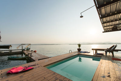 Swimming pool by sea against clear sky