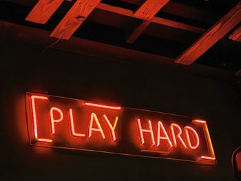 Low angle view of illuminated text on wall at night