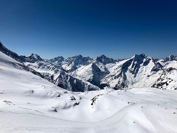 Scenic view of snowcapped mountains against clear blue sky