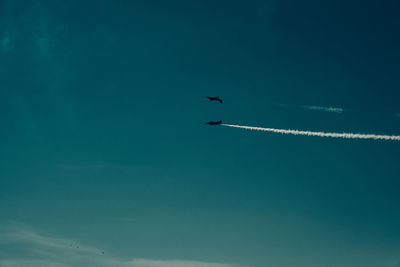 Low angle view of airplane against blue sky