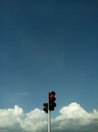 Low angle view of road sign against blue sky