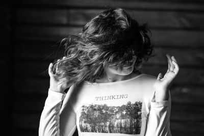 Rear view of woman standing against text