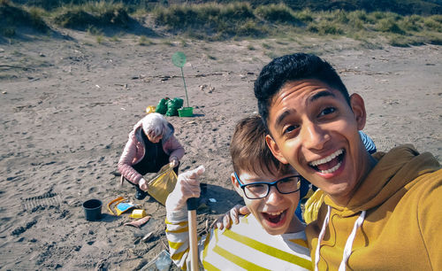 Portrait of cheerful brothers screaming at beach