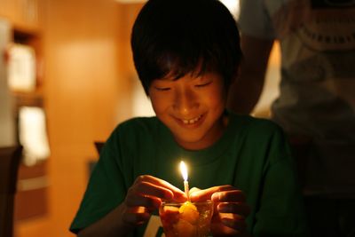 Close-up of boy with burning candles