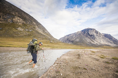 Rear view of boy on mountain against sky