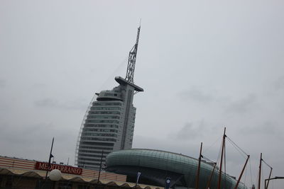 Low angle view of modern building against cloudy sky