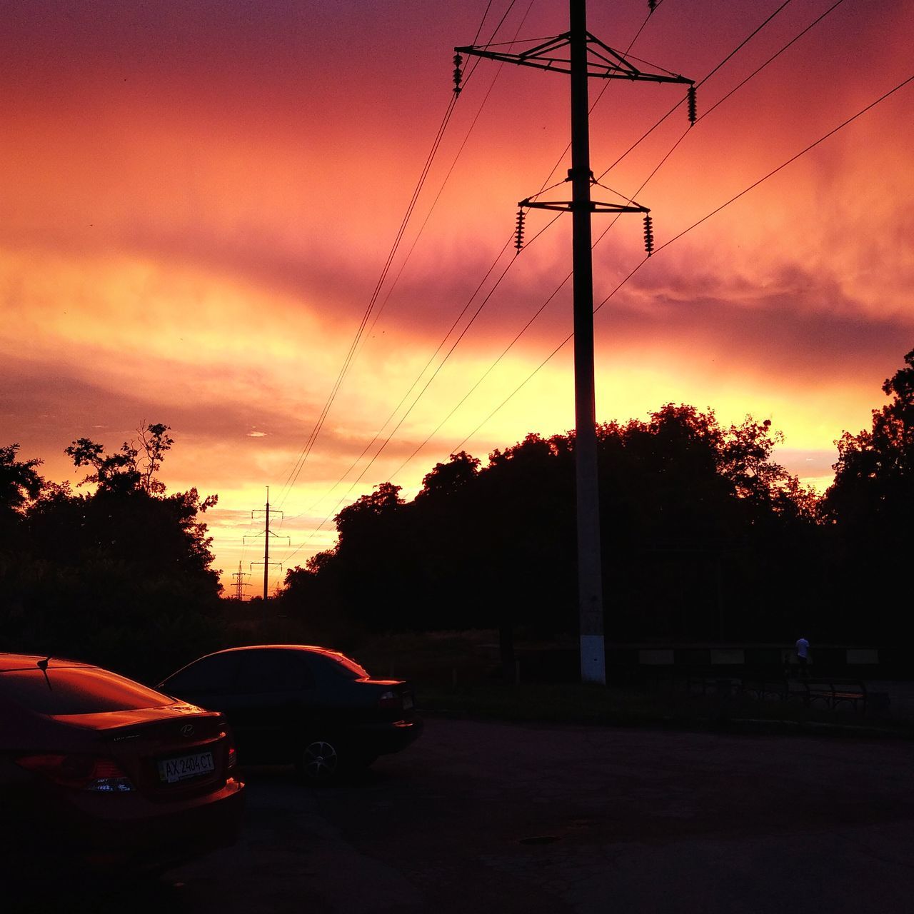sunset, sky, car, mode of transportation, motor vehicle, electricity, land vehicle, transportation, technology, tree, cable, power line, electricity pylon, cloud - sky, nature, no people, plant, silhouette, connection, orange color, power supply, outdoors