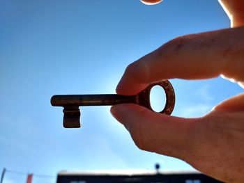 Close-up of hand holding blue against sky