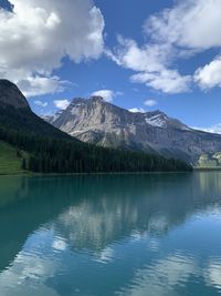 Scenic view of emerald lake by mountains against sky