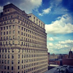 Buildings in city against cloudy sky