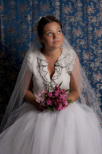 Portrait of beautiful woman standing against white wall