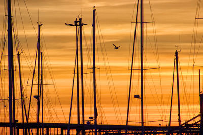Low angle view of silhouette sailboats against sky at sunset