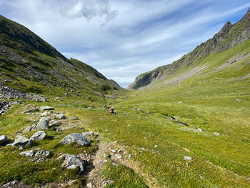 Scenic view of three people hiking with landscape against sky in lofoten